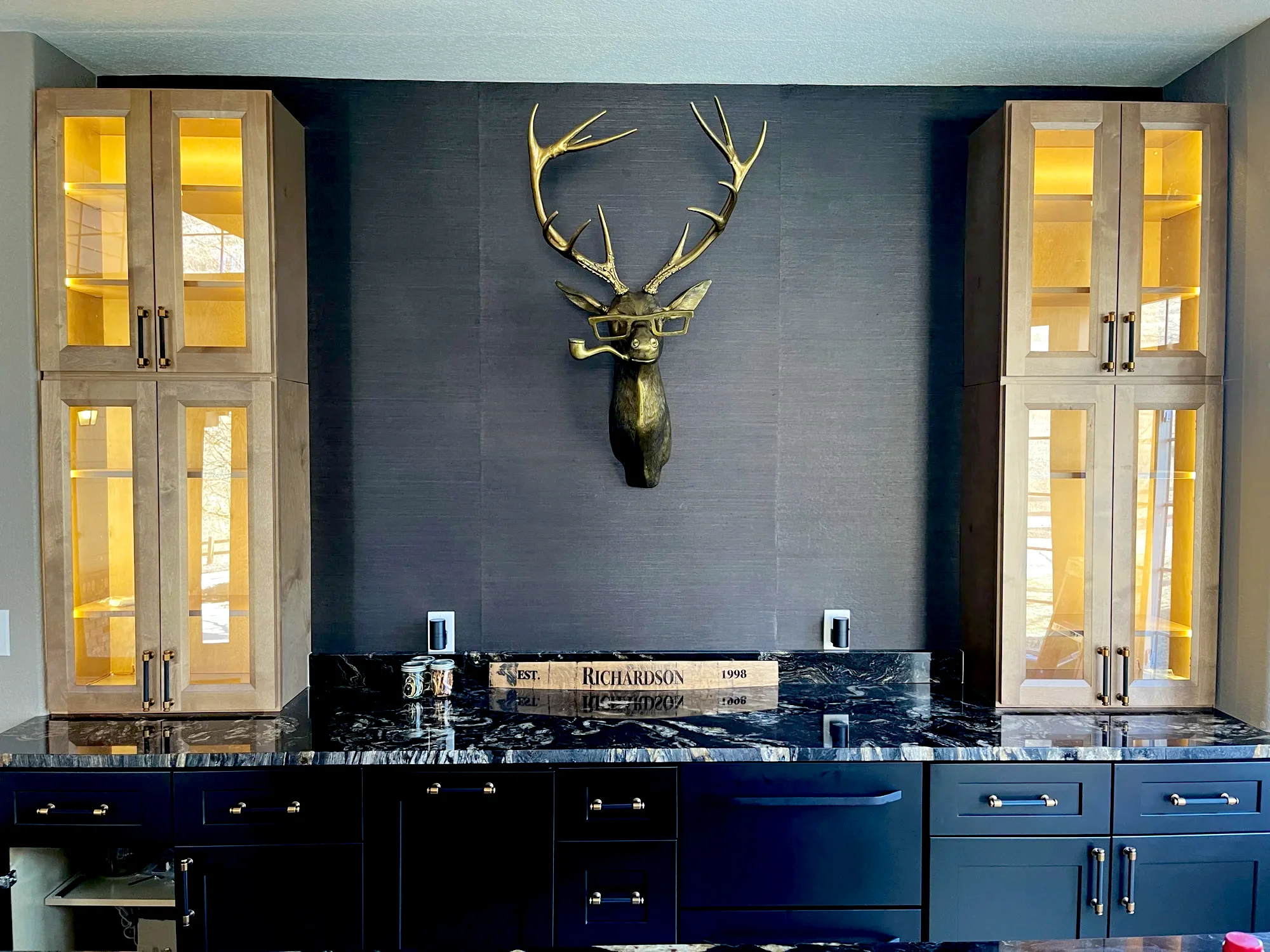 Bar and lounge with lit glass-front cabinets