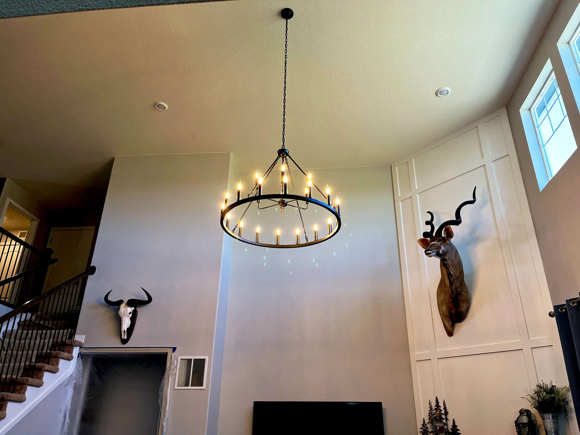 Two-story great room with the chandelier and recessed lighting