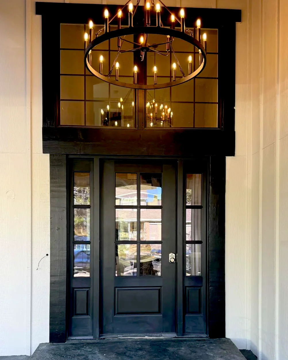 Entry chandelier seen through the transom above a black front door