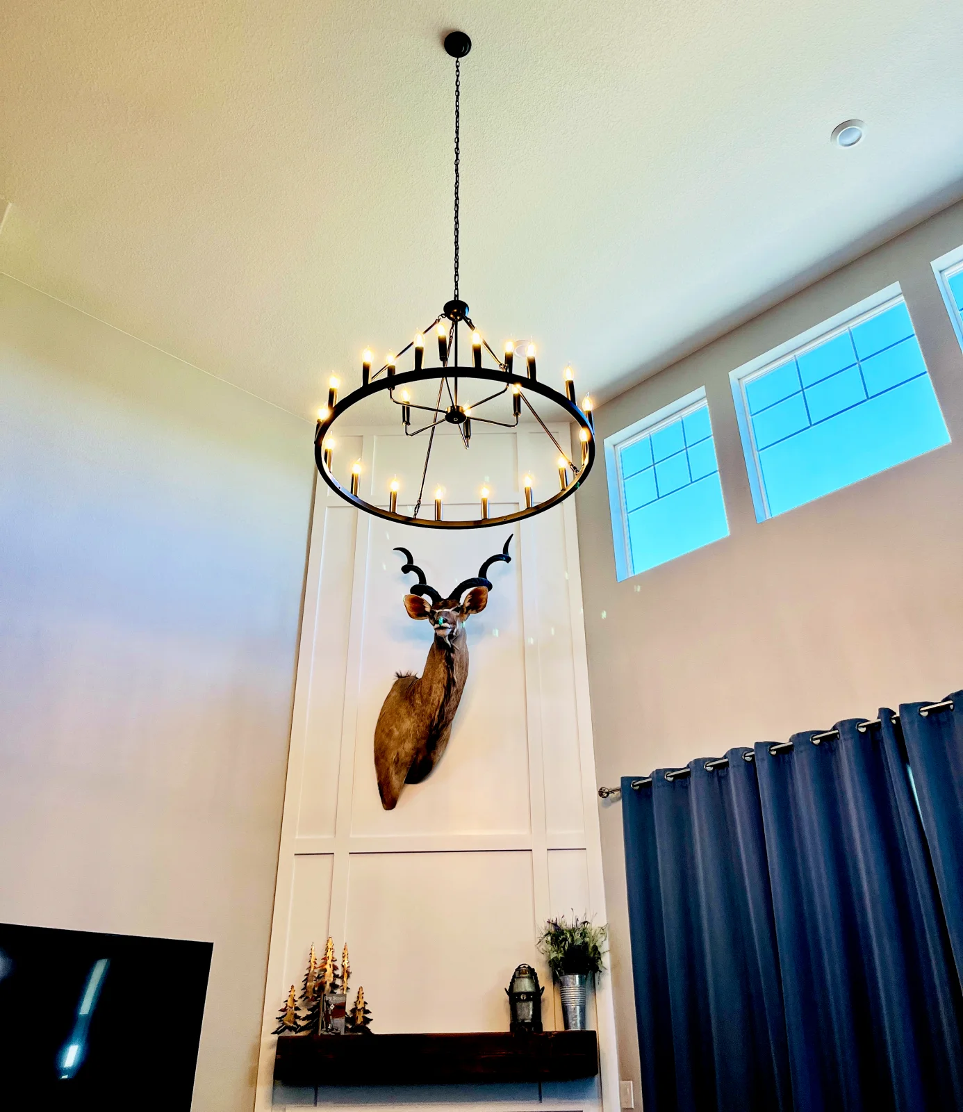Two-story great room with a large wagon-wheel chandelier