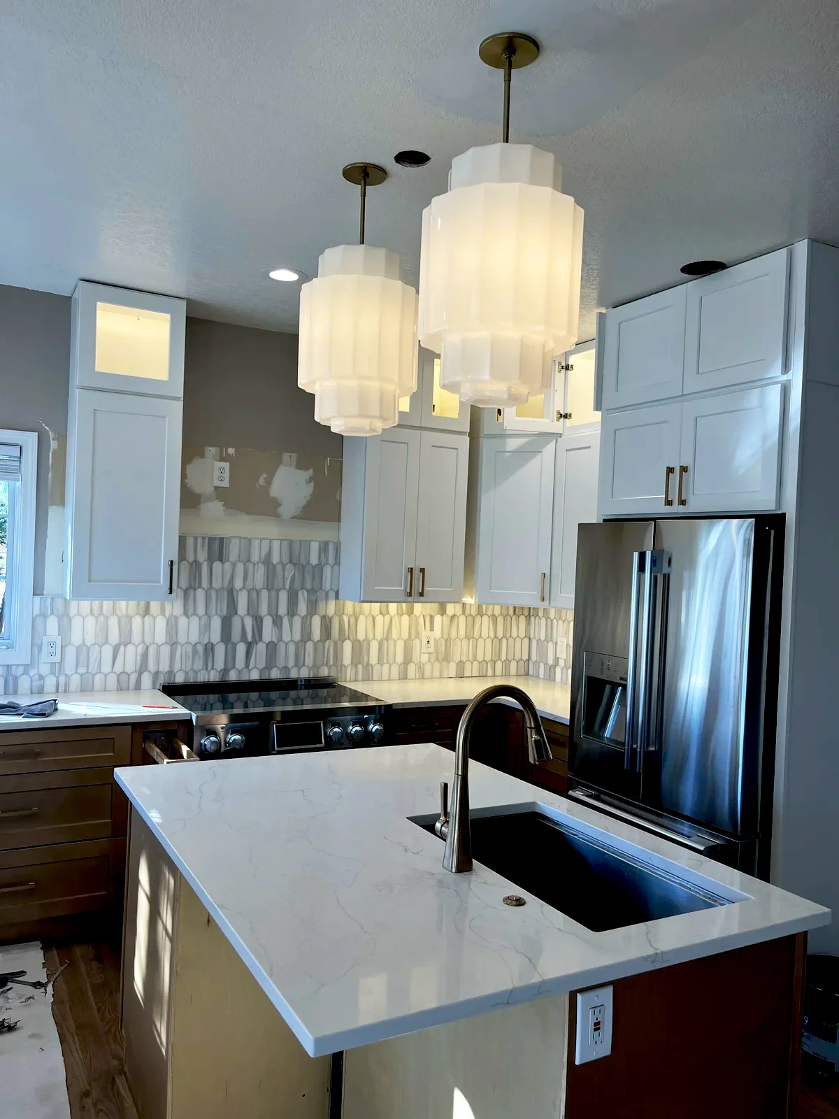 Kitchen island with white cylinder pendant lights