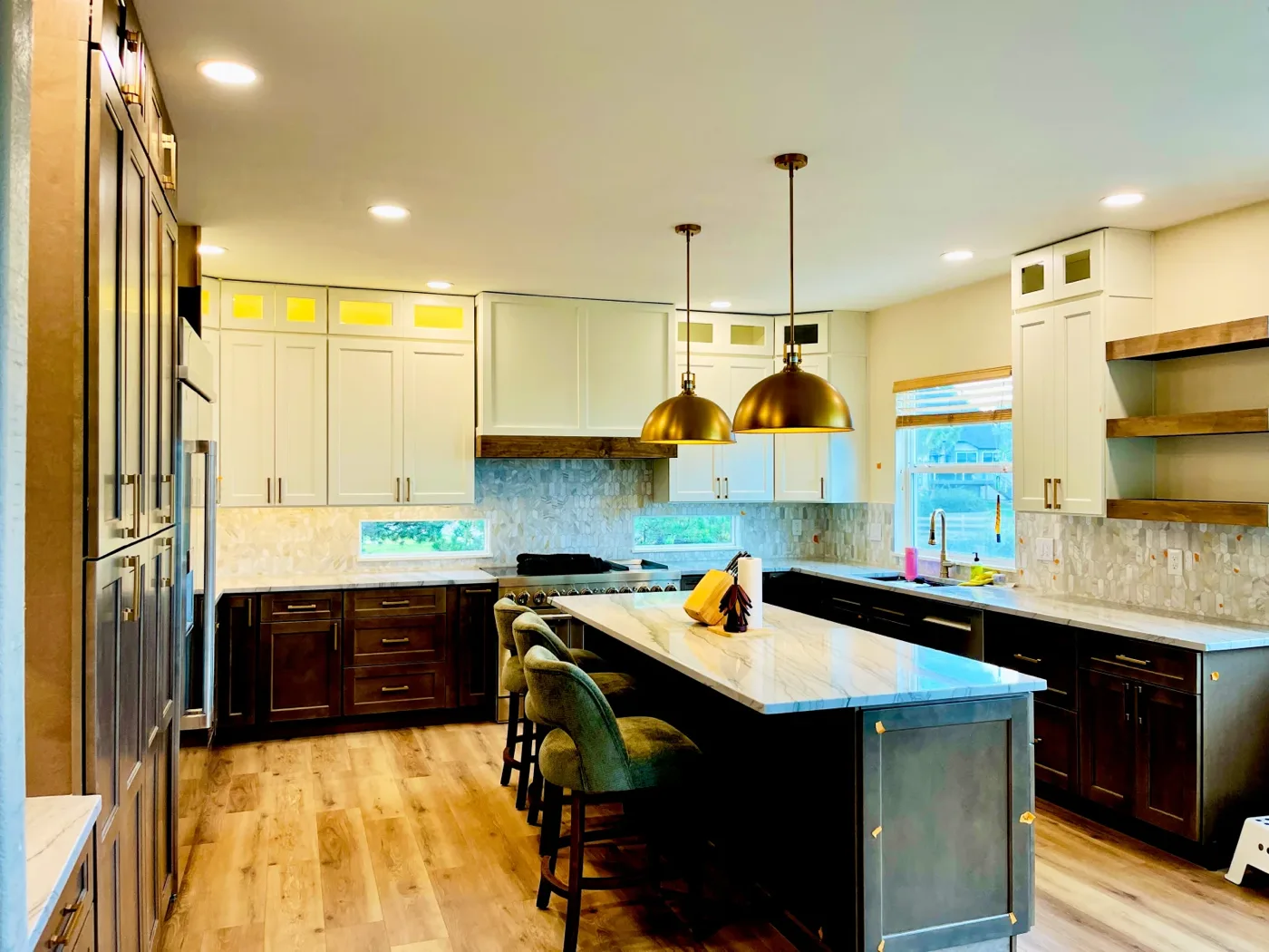 Wide view of the remodeled kitchen with brass pendants over the island