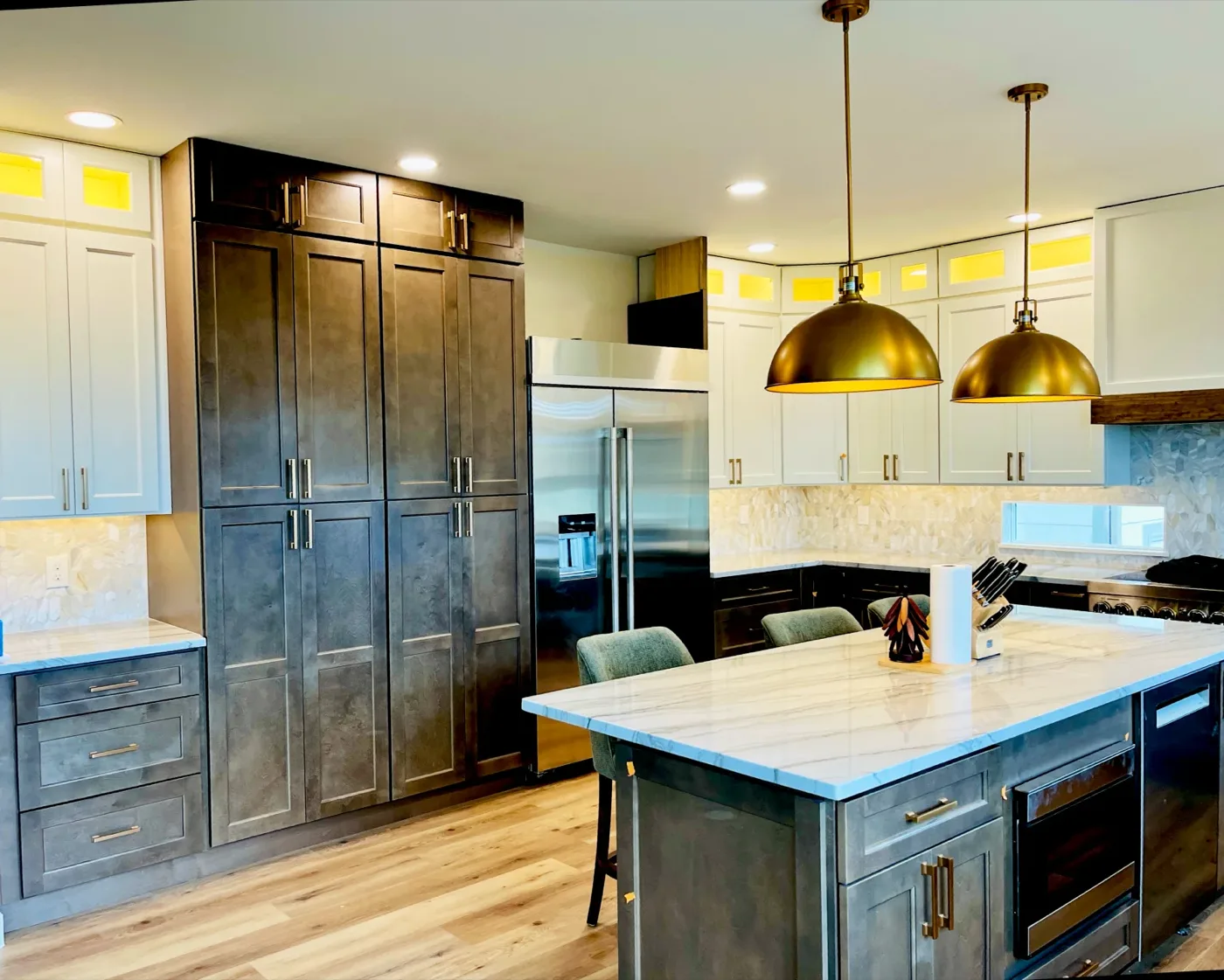 Kitchen remodel with brass dome pendants, cabinet uplights, and recessed lighting