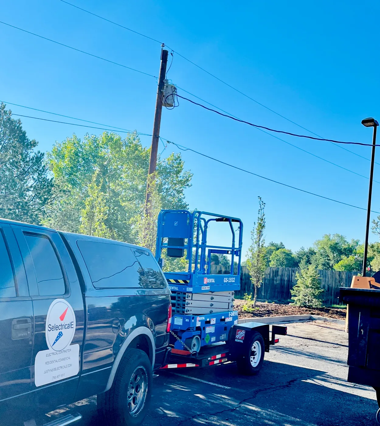 SelectricalE truck towing a scissor lift to a job site