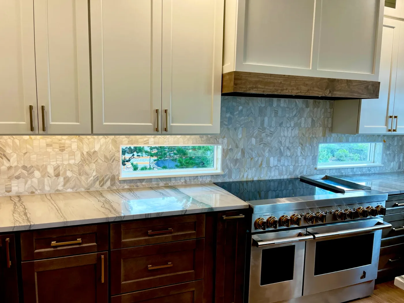 Kitchen range wall with marble backsplash and under-cabinet lighting