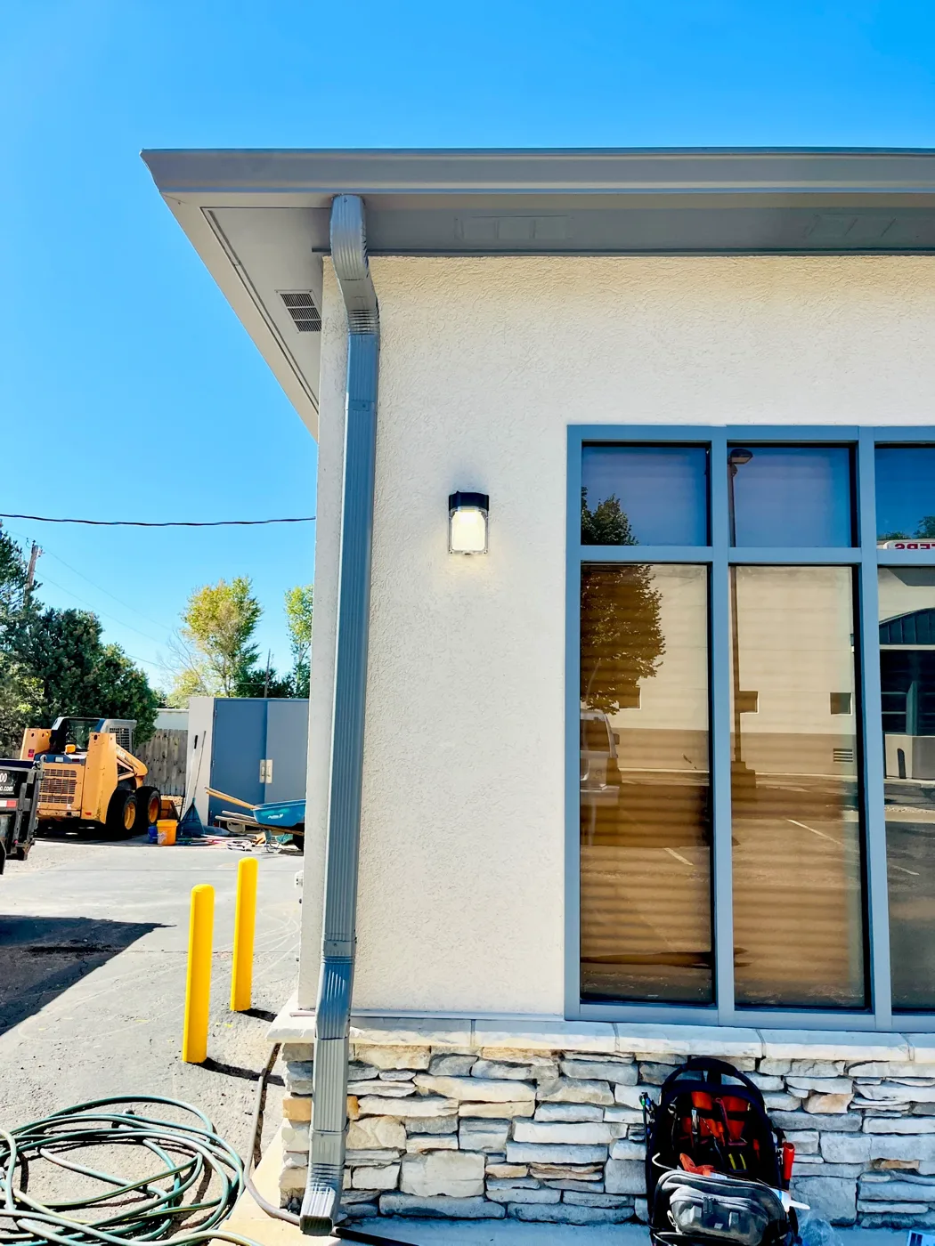 Exterior wall sconce on the corner of a stucco commercial building